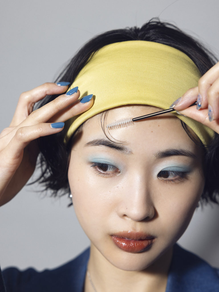 ヘアバンドを付けてオールバックにしたら、スクリューブラシで5本ほど前髪を引き出す